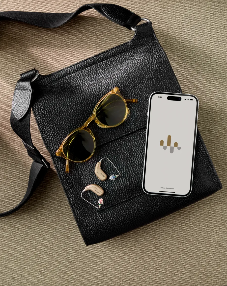 Oticon Intent miniRITE hearing aids with sunglasses and a bag